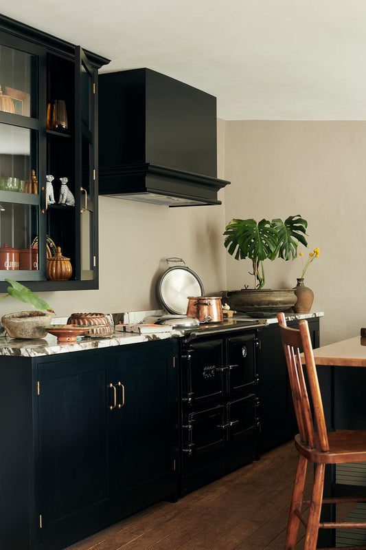 Devol Kitchens black counters with plants and antique decor