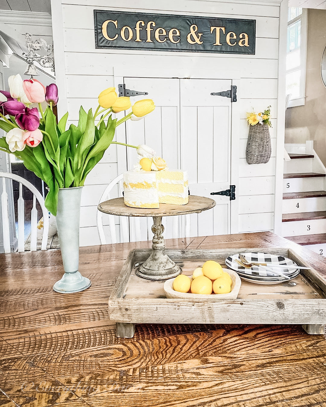 Faux lemon cake with pink and white tulips on wooden table