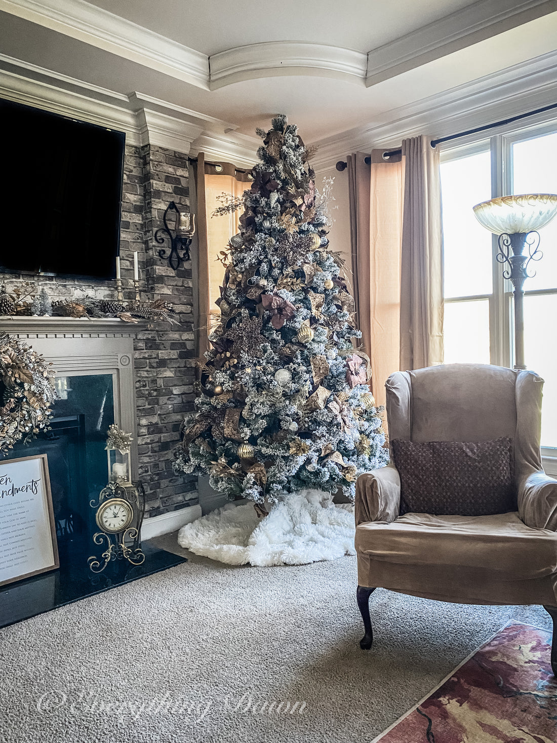 Christmas tree in corner of family room behind tan wing back chair 